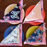 4 colorful fabric napkins on plates